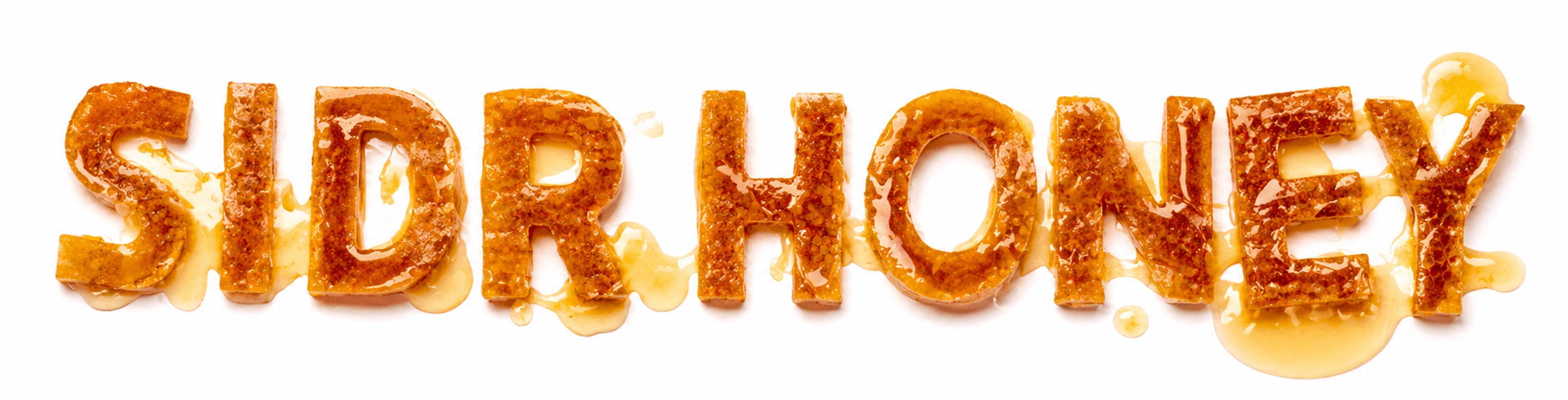 Sidr honey spelled in glossy honey letters with dripping texture on white background, showcasing natural Saudi Sidr honey quality and purity