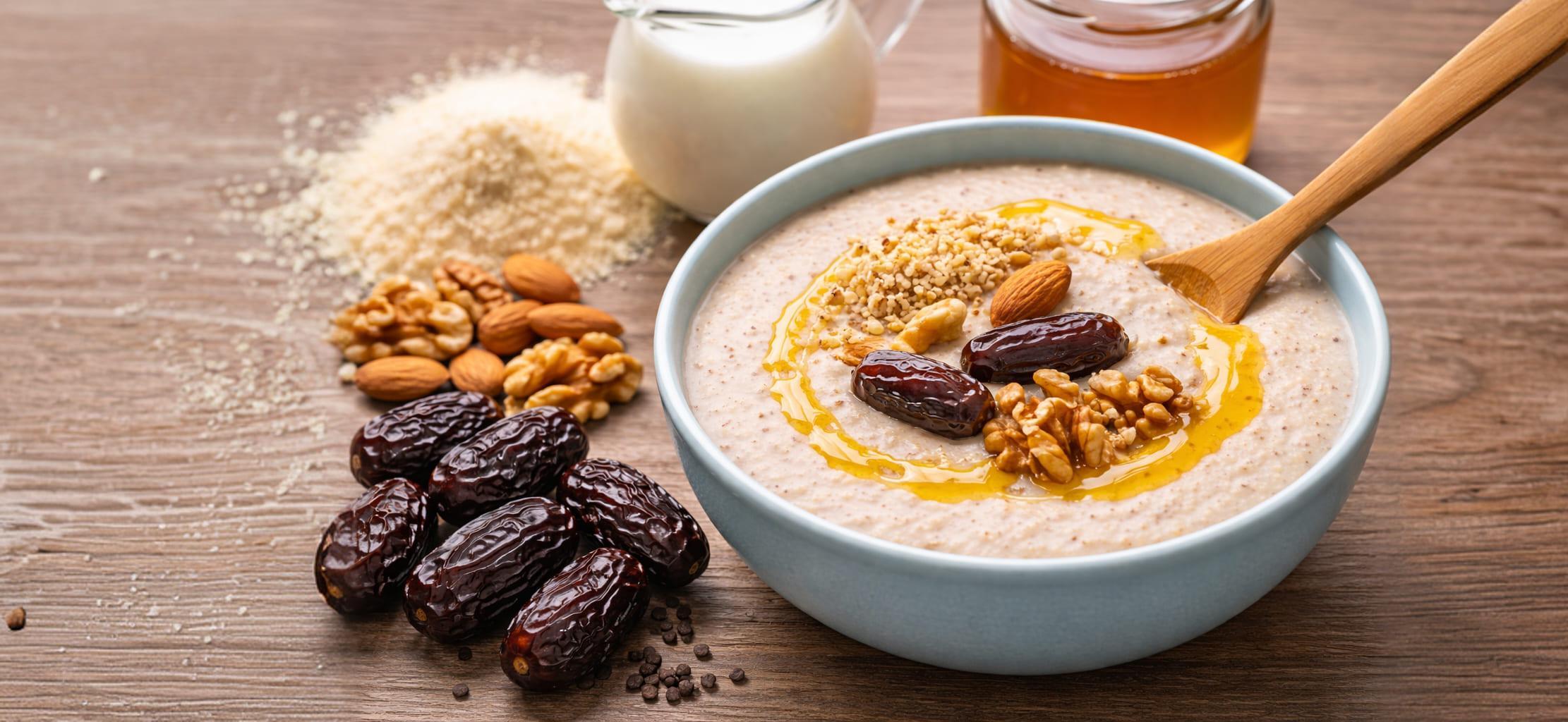 Talbina in bowl with dates, walnuts, almonds and honey toppings
